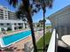 Inviting pool area with palm trees and ocean views from condo balcony at 4225 S Atlantic Ave # 218, New Smyrna Beach, FL 32169