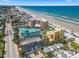 Aerial view of beachfront condos, a parking lot, and the stunning beach and ocean at 425 S Atlantic Ave # 302, New Smyrna Beach, FL 32169