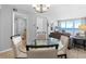 Open-concept dining area featuring a glass table, seating for four, and ocean views at 425 S Atlantic Ave # 302, New Smyrna Beach, FL 32169