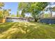 Large backyard featuring green grass, mature trees, and a shed, offering ample space for outdoor activities at 431 Palmetto St, Edgewater, FL 32132