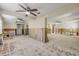 Spacious living room revealing its subflooring with ceiling fans and evidence of wall remediation after water damage at 431 Palmetto St, Edgewater, FL 32132