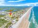 Beautiful aerial view of beachfront community in a sunny coastal area with an ocean view at 4350 Candlewood Ln, Ponce Inlet, FL 32127