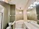 Bright bathroom featuring garden tub, dual sinks, decorative lighting, and neutral color palette at 439 Bouchelle Dr # 202, New Smyrna Beach, FL 32169