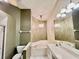 Bright bathroom featuring garden tub, dual sinks, decorative lighting, and neutral color palette at 439 Bouchelle Dr # 202, New Smyrna Beach, FL 32169