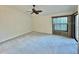 Large bedroom with neutral carpet, a ceiling fan, and a sliding glass door at 439 Bouchelle Dr # 202, New Smyrna Beach, FL 32169
