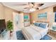 Stylishly decorated bedroom with bed, blue accents, beach themed art, and ample natural light at 439 Bouchelle Dr # 202, New Smyrna Beach, FL 32169