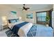 This primary bedroom features a ceiling fan, a dresser, and a decorated queen-size bed at 439 Bouchelle Dr # 202, New Smyrna Beach, FL 32169