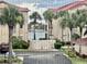 Multi-story buildings with red roofs and palm trees overlook a canal on a sunny day at 439 Bouchelle Dr # 202, New Smyrna Beach, FL 32169