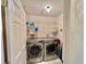 A well-lit laundry room featuring a washer, dryer, and wire shelving for storage at 439 Bouchelle Dr # 202, New Smyrna Beach, FL 32169
