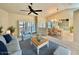 Bright living room boasts stylish furnishings, a ceiling fan, and sliding glass doors to the outside at 439 Bouchelle Dr # 202, New Smyrna Beach, FL 32169