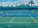 Fenced community tennis court featuring lines for play and a net at 439 Bouchelle Dr # 202, New Smyrna Beach, FL 32169
