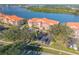 Lovely aerial view of a condo complex with ample parking and tree covered green spaces at 460 Bouchelle Dr # 104, New Smyrna Beach, FL 32169