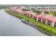 Stunning aerial view of condos along the water with docks, lush landscaping, and a city skyline at 460 Bouchelle Dr # 104, New Smyrna Beach, FL 32169