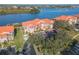 Stunning aerial view of the condo complex with an orange roof, lush landscaping, and waterfront views at 460 Bouchelle Dr # 104, New Smyrna Beach, FL 32169