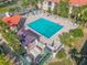 Aerial view of a community pool area with lounge seating, and shade, surrounded by lush palms at 460 Bouchelle Dr # 104, New Smyrna Beach, FL 32169