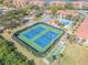 Wide aerial view of community tennis and shuffleboard courts, set among lush landscaping at 460 Bouchelle Dr # 104, New Smyrna Beach, FL 32169