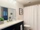 Bright bathroom with a dark vanity, white countertop, and framed artwork at 460 Bouchelle Dr # 104, New Smyrna Beach, FL 32169