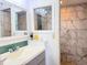 Bright bathroom featuring double vanity and walk-in shower with stone pebble floor at 460 Bouchelle Dr # 104, New Smyrna Beach, FL 32169