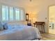 Comfortable bedroom with queen-sized bed, plush bedding, and decorative shuttered window at 460 Bouchelle Dr # 104, New Smyrna Beach, FL 32169