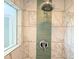 Close up of shower with marble look tile and green tile accent stripe at 460 Bouchelle Dr # 104, New Smyrna Beach, FL 32169