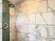 Close up of shower with tile accent wall and stone pebble floor at 460 Bouchelle Dr # 104, New Smyrna Beach, FL 32169