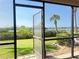 A peaceful outdoor view from the screened in patio, featuring lush greenery and a glimpse of the waterfront at 460 Bouchelle Dr # 104, New Smyrna Beach, FL 32169