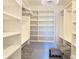 Bright walk-in closet with custom shelving, hanging rods and a decorative chandelier at 460 Bouchelle Dr # 104, New Smyrna Beach, FL 32169