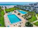 Breathtaking aerial view of multiple community pools, beach access, lush greenery, and stunning ocean views at 4841 Saxon Dr # C201, New Smyrna Beach, FL 32169