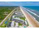 Sweeping aerial showcases the condos next to the beach, with tennis courts and pools at 4841 Saxon Dr # C201, New Smyrna Beach, FL 32169