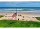 Scenic beach view featuring an American flag, tables, chairs, and oceanfront access for residents and their guests at 4841 Saxon Dr # C201, New Smyrna Beach, FL 32169