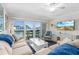 Bright living room featuring comfortable seating, a ceiling fan, a tv, and a balcony with ocean views at 4841 Saxon Dr # C201, New Smyrna Beach, FL 32169