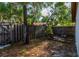 A fenced-in backyard with tree coverage and leaves on the ground at 5 Soco Trl, Ormond Beach, FL 32174