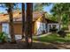 Charming home exterior featuring a brown garage door, well-manicured lawn, and mature trees at 5 Soco Trl, Ormond Beach, FL 32174