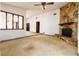 Inviting living room with stone fireplace, neutral carpet, and decorative ceiling fan at 5 Soco Trl, Ormond Beach, FL 32174
