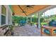 Outdoor patio with covered dining area and barbecue space overlooking the backyard at 508 Faulkner St, New Smyrna Beach, FL 32168
