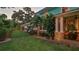 Exterior view of a home with a gated entrance, lush landscaping, and stone accents, illuminated at dusk at 508 Faulkner St, New Smyrna Beach, FL 32168