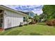 Exterior view of a white house with a well-maintained lawn and gated entrance surrounded by lush greenery at 508 Faulkner St, New Smyrna Beach, FL 32168