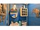 Stylish half bathroom featuring a round mirror, pedestal sink, and blue plank walls at 508 Faulkner St, New Smyrna Beach, FL 32168
