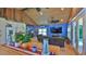 Open concept living room with brick floors, beamed ceilings, and comfortable leather seating around a TV at 508 Faulkner St, New Smyrna Beach, FL 32168