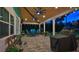 Covered outdoor patio with ceiling fans, string lights, dining area, and comfortable seating at 508 Faulkner St, New Smyrna Beach, FL 32168