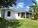 Exterior view of a home featuring a back porch, brick patio and lush backyard at 519 Aeolian Dr, New Smyrna Beach, FL 32168
