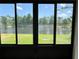 Scenic view of a serene lake and lush greenery through sliding glass doors at 519 Aeolian Dr, New Smyrna Beach, FL 32168