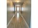Long hallway with wood floors and neutral-colored walls leading to a door at 519 Aeolian Dr, New Smyrna Beach, FL 32168