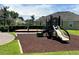 Community playground features a slide and swingset surrounded by lush grass and mature trees at 519 Aeolian Dr, New Smyrna Beach, FL 32168