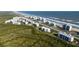 Aerial shot showing ocean front condos, parking, lush greenary, and community tennis courts at 5300 S Atlantic Ave # 17-207, New Smyrna Beach, FL 32169