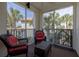Relaxing screened balcony with wicker furniture and a view of swaying palm trees at 5300 S Atlantic Ave # 17-207, New Smyrna Beach, FL 32169