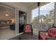 Screened balcony showing comfortable seating and a peek into the primary bedroom at 5300 S Atlantic Ave # 17-207, New Smyrna Beach, FL 32169