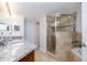 Bright bathroom featuring a glass-enclosed shower and a granite-topped vanity with double sinks at 5300 S Atlantic Ave # 17-207, New Smyrna Beach, FL 32169