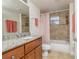 Neutral bathroom featuring granite countertops, tile shower with tub, and peach towels hanging from the rack at 5300 S Atlantic Ave # 17-207, New Smyrna Beach, FL 32169