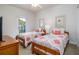Twin beds featuring patterned bedding and a door leading to an outdoor balcony at 5300 S Atlantic Ave # 17-207, New Smyrna Beach, FL 32169